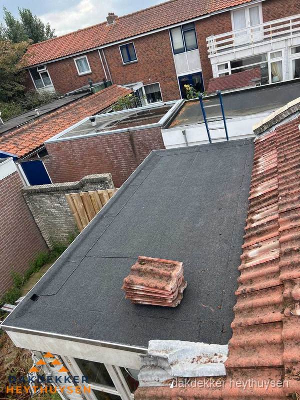 Plat dak aanbouw met bitumen naast schuin pannendak in Heythuysen Plat dak aanbouw met bitumen naast schuin pannendak in Heythuysen