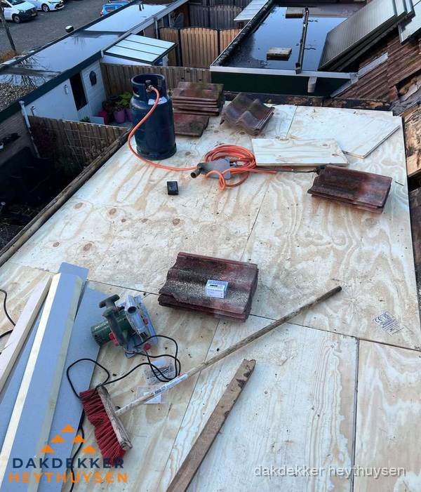 Dakreparatie werkzaamheden op plat dak met gereedschap in Heythuysen