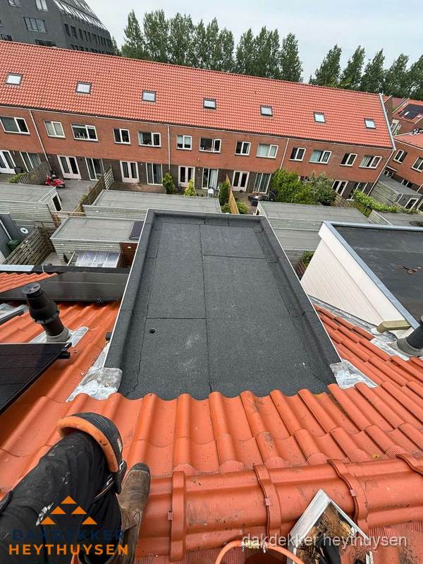 Bitumen dak reparatie op plat dak tussen dakpannen in Heythuysen