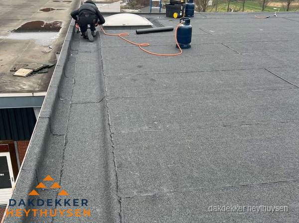 Dakdekker repareert bitumen dakbedekking op groot plat dak in Heythuysen Dakdekker repareert bitumen dakbedekking op groot plat dak in Heythuysen