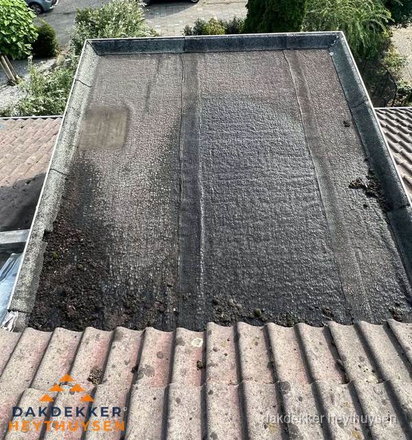 Verouderd plat dak met bitumen en slijtage voor lekkage inspectie in Heythuysen Verouderd plat dak met bitumen en slijtage voor lekkage inspectie in Heythuysen