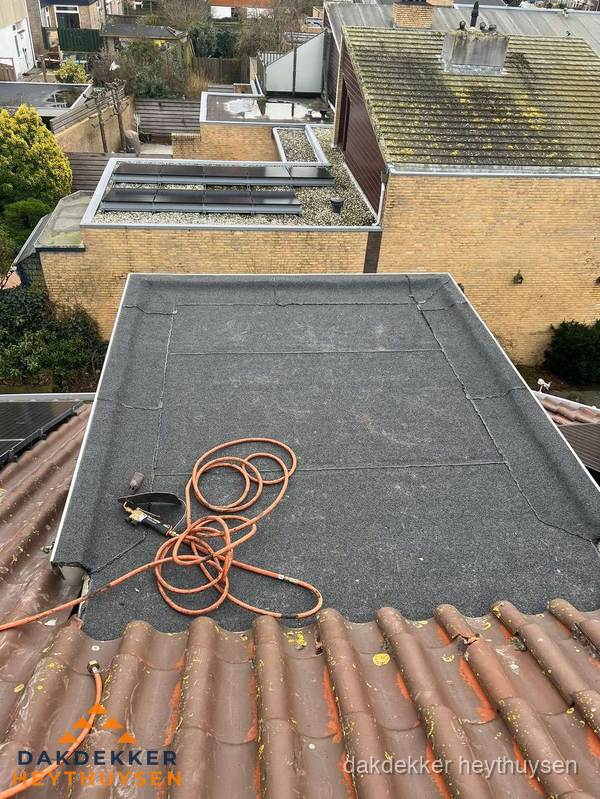 Reparatie aansluiting plat dak en schuin dak in Heythuysen