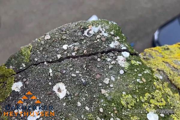 Beschadigde en verweerde nokvorst met scheuren en mos in Heythuysen Beschadigde en verweerde nokvorst met scheuren en mos in Heythuysen
