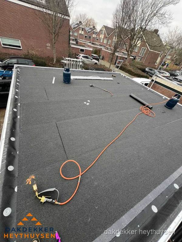 Afgewerkte dakrenovatie met bitumen op plat dak in Heythuysen
