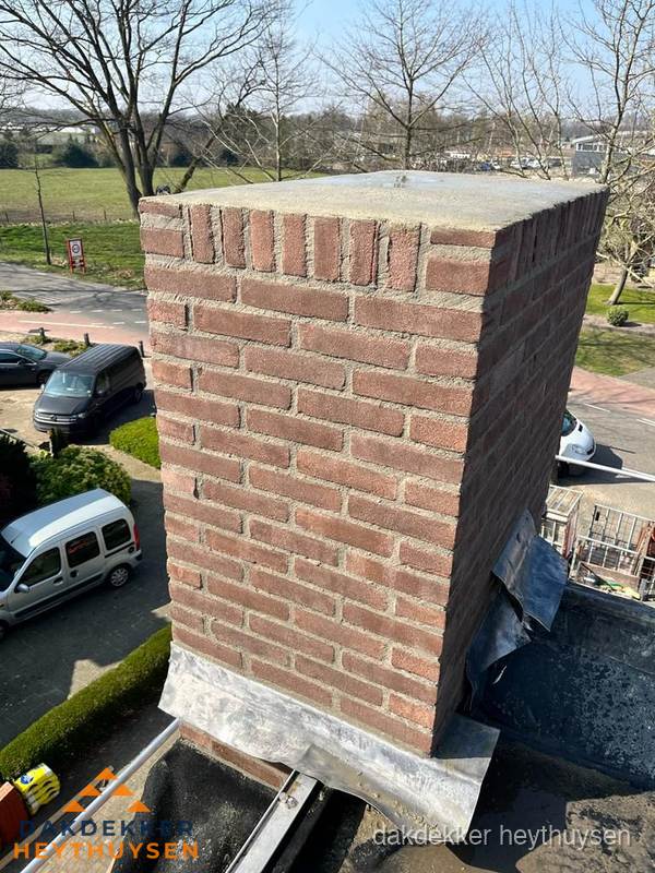 Gemetselde schoorsteen met loodaansluiting op dak in Heythuysen Gemetselde schoorsteen met loodaansluiting op dak in Heythuysen