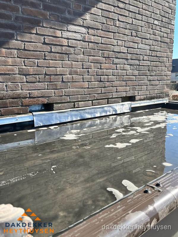 Stilstaand water op plat dak door slechte afwatering in Heythuysen Stilstaand water op plat dak door slechte afwatering in Heythuysen