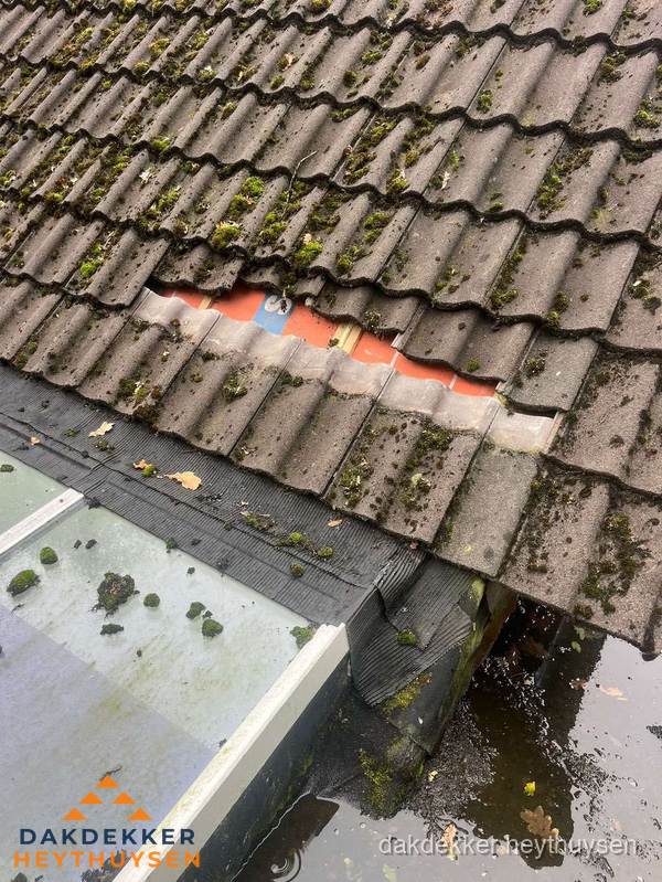Beschadigd pannendak met ontbrekende dakpannen voor reparatie in Heythuysen