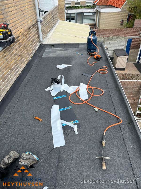 Dakdekkers bezig met bitumen dakbedekking in Heythuysen